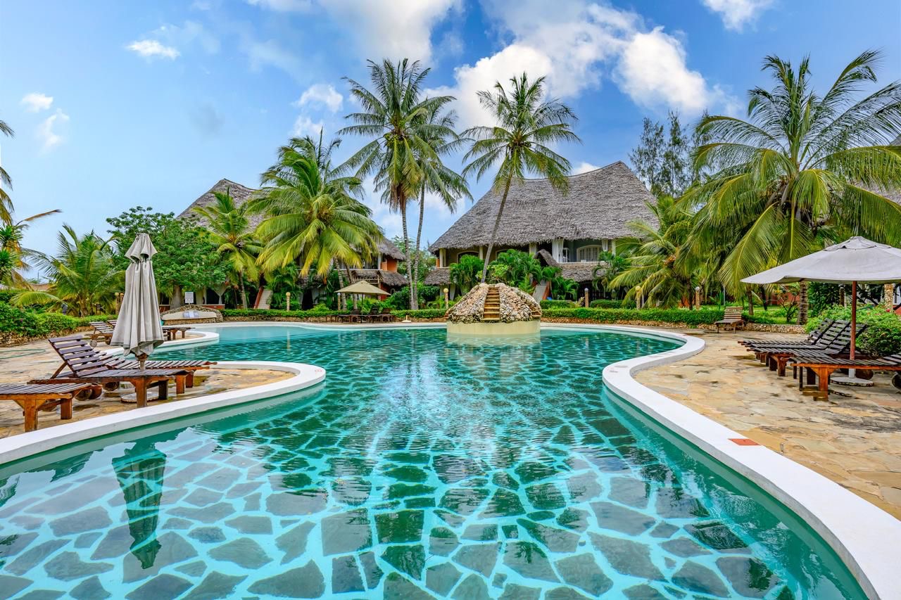 Aerial view of the resort pool with blue water and lush garden landscaping